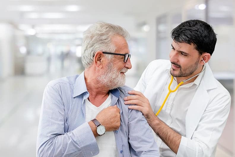 doctor taking elderly man's heart rate